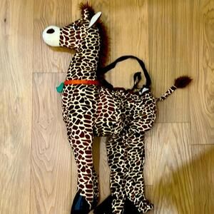 Halloween costume kids sit inside with arm straps stuffie giraffe.